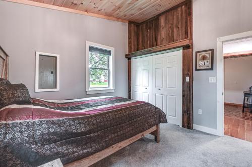 a bedroom with a large bed and a door at Near State Parks Countryside Cottage in Wellsboro in Wellsboro