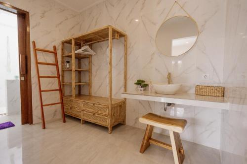 baño con lavabo, espejo y escalera en The Buddha Villa by Homely Bali, en Kerobokan
