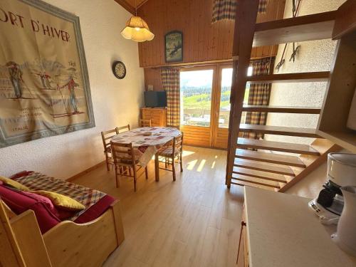 un salon avec une table et des chaises et un escalier dans l'établissement Appartement 2 pièces cabine 8 personnes, balcon sud, central aux Saisies - FR-1-594-50, à Hauteluce