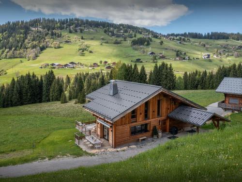 une cabane en rondins au milieu d'un champ verdoyant dans l'établissement Chalet 1786 - OVO Network, à Notre-Dame-de-Bellecombe
