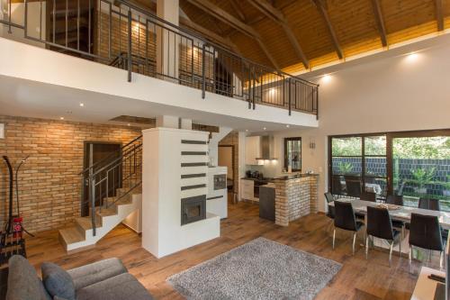 a living room with a staircase and a dining room at Griff Apartman in Balatonföldvár