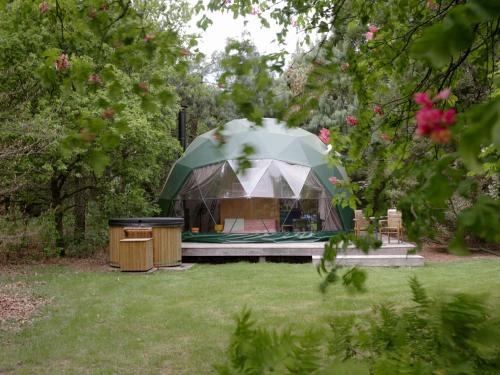 a tent in the middle of a yard at Stay Classy - Domes in Otterlo
