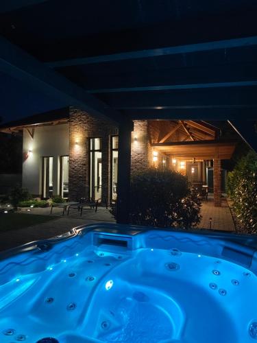 a hot tub in front of a house at night at Griff Apartman in Balatonföldvár