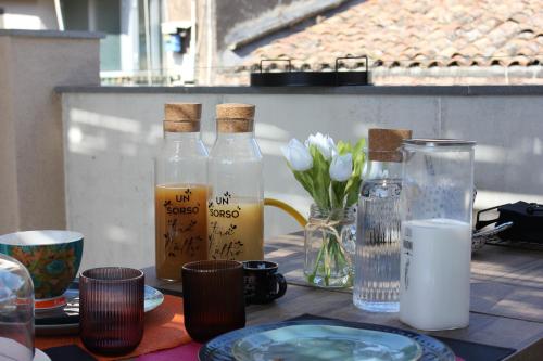 a table with bottles and plates and glasses on it at Roby's Boutique Rooms - Luxury B&B in Catania