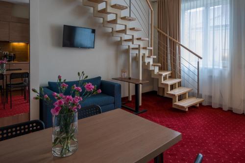 a living room with a vase of flowers on a table at Agneta Apartamentai in Druskininkai
