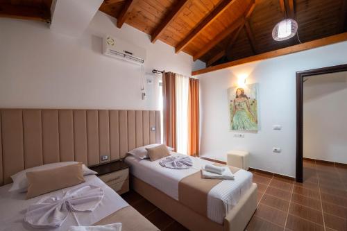 a bedroom with two beds and a painting on the wall at Villa JIOTA in Ksamil