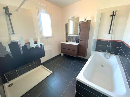 ein Badezimmer mit Badewanne und Waschbecken in der Unterkunft Belle maison avec jardin clos proche plage à l'ILE GRANDE - Réf 291 in Pleumeur-Bodou
