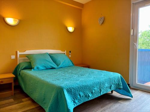 une chambre avec un lit avec une couette bleue et une fenêtre dans l'établissement Belle Appartement T2 Plage Centrale Argeles sur mer 2, à Argelès-sur-Mer