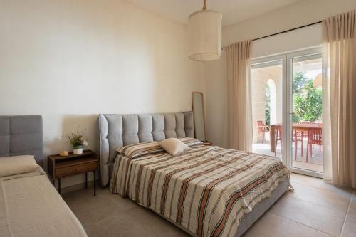 Un dormitorio con una cama y una puerta corrediza de vidrio. en Casa Due Fichi, en San Pietro in Bevagna