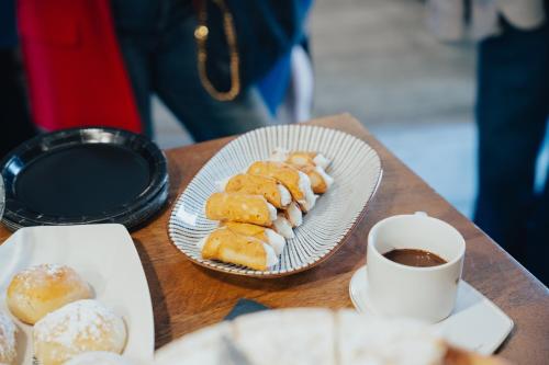 a table with plates of pastries and a cup of coffee at Roby's Boutique Rooms - Luxury B&B in Catania