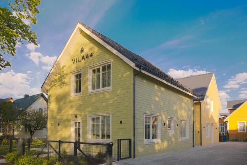 a yellow building with a sign on the side of it at Vila 44 in Druskininkai