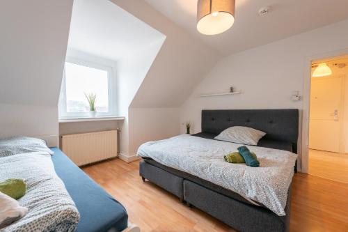 ein Schlafzimmer mit zwei Betten und einem Fenster in der Unterkunft HagenStay Mittelstadt 1 in Hagen