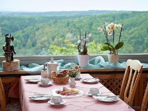 einen Tisch mit einem rosa Tischtuch und Teller mit Lebensmitteln in der Unterkunft Ritterschänke in Essing