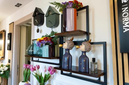 a shelf with vases and flowers on it at Roby's Boutique Rooms - Luxury B&B in Catania