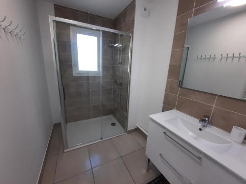 une salle de bain avec douche et lavabo dans l'établissement Appartement neuf et climatisé, 6 personnes, à 150m de la plage, à Vias