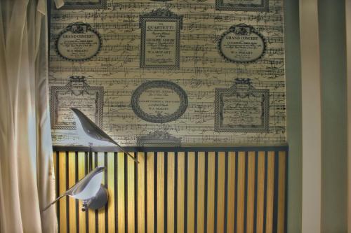 a room with a curtain and a wall with a wallpaper at Roby's Boutique Rooms - Luxury B&B in Catania