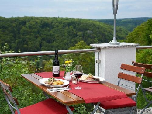 a table with two plates of food and a bottle of wine at Ritterschänke in Essing