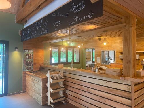 a restaurant with a counter with wooden walls at Huttopia Rambouillet in Rambouillet