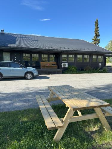 a picnic table in front of a building with a car at Karivollen Overnatting in Melhus
