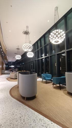 a lobby with chairs and chandeliers in a building at Homestay Service Apartment Meta City Seri Kembangan-Putrajaya-Puchong-KL in Seri Kembangan