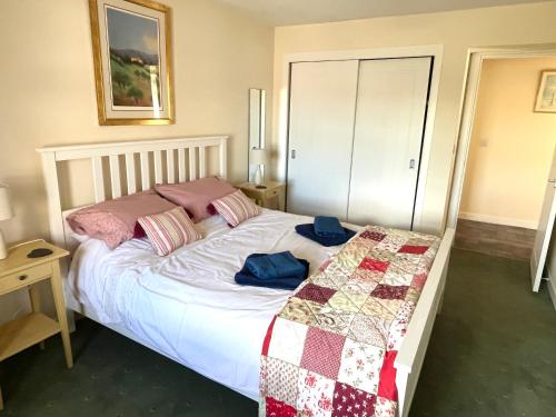 a bedroom with a bed with a quilt on it at House By The Sea in Portsoy