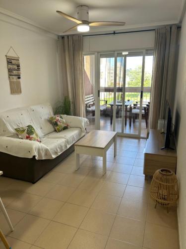 ein Wohnzimmer mit Sofa und Tisch in der Unterkunft Descanso y jardines con piscinas in Arenales del Sol