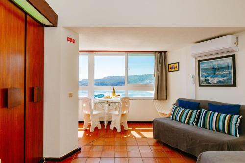 a living room with a couch and a table at Rent4rest - Sesimbra Ocean View Studio in Sesimbra