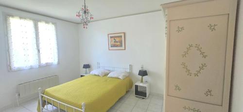 une chambre avec un lit avec une couverture jaune dans l'établissement Gite Saint Irénée, à Béziers