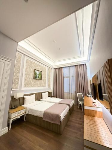 a hotel room with a large bed and a window at Theatrum Hotel Baku in Baku