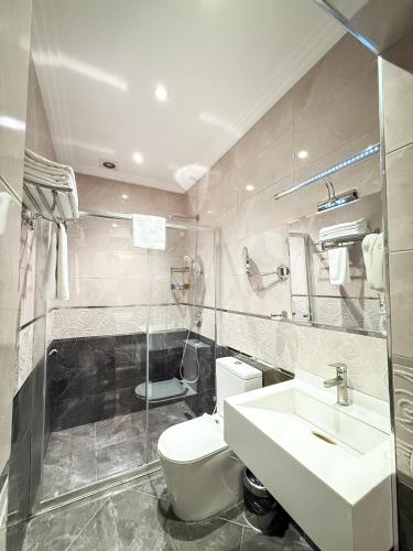 a bathroom with a white toilet and a sink at Theatrum Hotel Baku in Baku