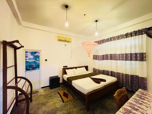 a room with two beds and a table in it at Crystal Wave in Weligama