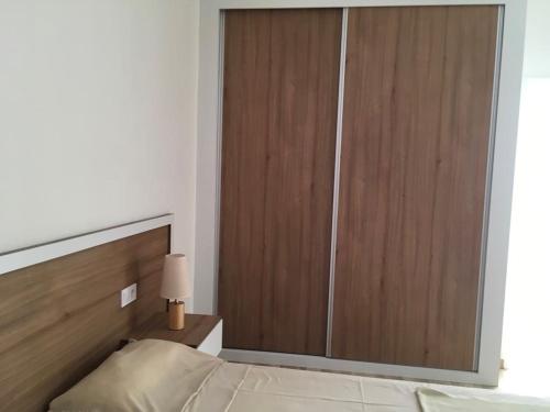a large wooden door in a bedroom with a bed at Alana's loft in Praia