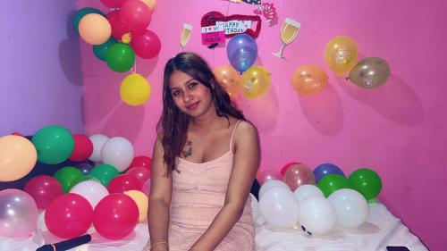 a young girl sitting in front of a bunch of balloons at TEC Resort and bar in Dharān Bāzār