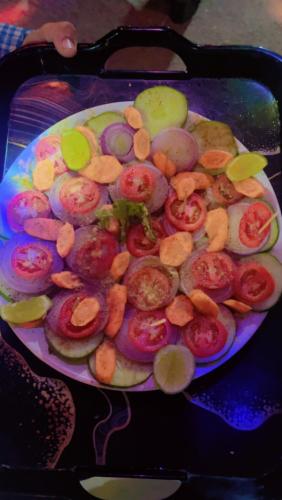a plate of food with tomatoes and other foods on it at TEC Resort and bar in Dharān Bāzār
