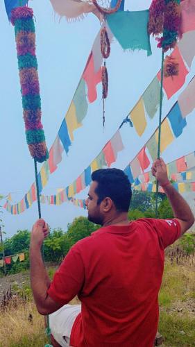a man in a red shirt holding up a kite at TEC Resort and bar in Dharān Bāzār