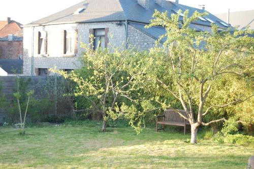 a bench sitting in a yard in front of a house at Gîte de la Fontaine in Beauraing