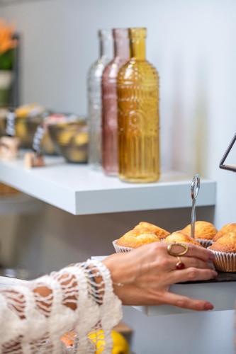 a woman is reaching for a plate of pastries at La Muntanya in Llafranc