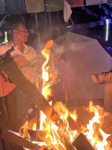 a man cooking over a fire in a grill at TEC Resort and bar in Dharān Bāzār