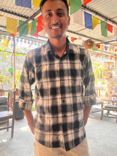 a man in a plaid shirt is posing for a picture at TEC Resort and bar in Dharān Bāzār