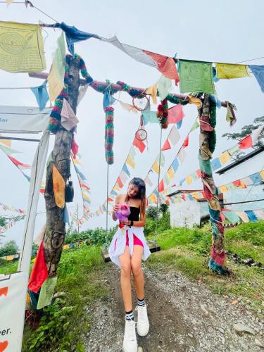 a woman sitting in front of a tent with flags at TEC Resort and bar in Dharān Bāzār