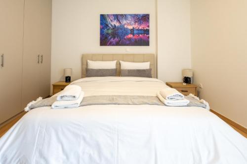 a bedroom with a large bed with white sheets at Elegant Sea View Stay - Piraeus Port in Piraeus