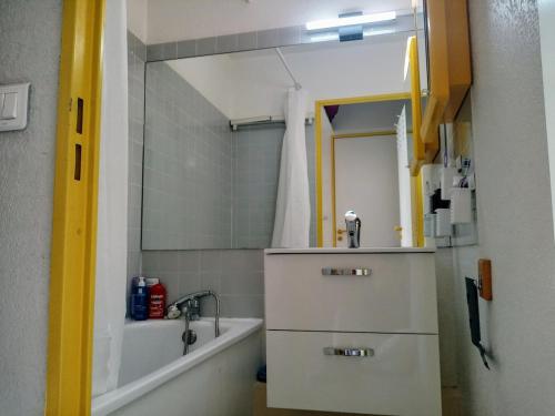 une salle de bain avec un lavabo, une baignoire et un miroir dans l'établissement Studio Vue magique pleine mer, port, cap Béar, Racou, Climatisé, à Argelès-sur-Mer