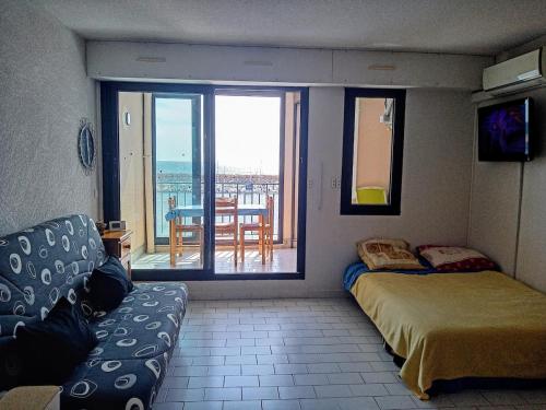 Cette chambre dispose d'un canapé, d'un lit et d'un balcon. dans l'établissement Studio Vue magique pleine mer, port, cap Béar, Racou, Climatisé, à Argelès-sur-Mer