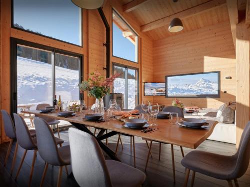 une salle à manger avec une grande table et des chaises en bois dans l'établissement Chalet NDB - OVO Network, à Notre-Dame-de-Bellecombe
