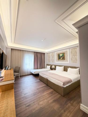 a hotel room with two beds and a desk at Theatrum Hotel Baku in Baku
