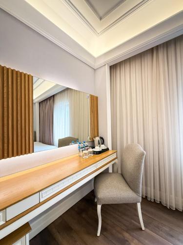 a hotel room with a desk and a mirror at Theatrum Hotel Baku in Baku