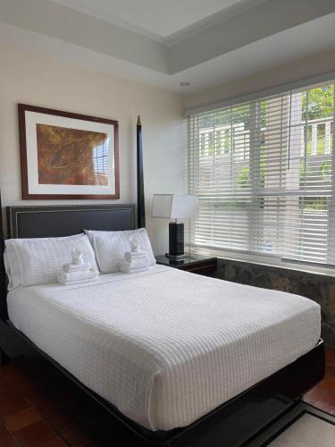 a bedroom with a large white bed and a window at Stonetrail in Arnos Vale