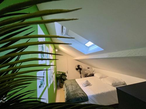 une chambre avec un lit et un mur végétal dans l'établissement Le Jungle - Rivière - 4 Pers - Rêve au Mans, au Mans