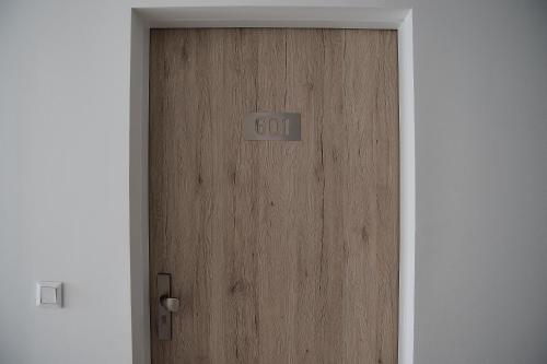 a wooden door with the word god written on it at Napfény Resort by HelloBalatonlelle in Balatonlelle