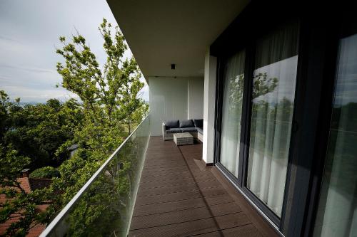 a balcony of a house with a couch on it at Napfény Resort by HelloBalatonlelle in Balatonlelle